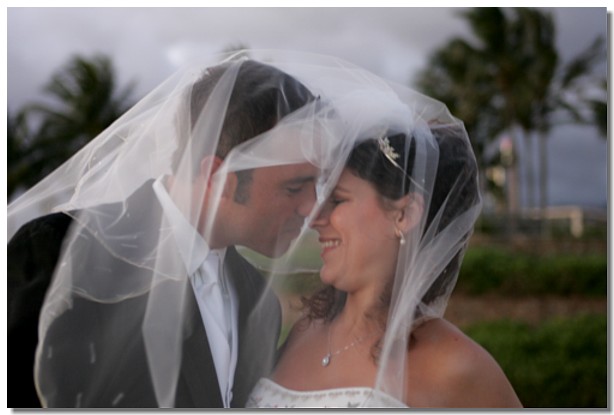 Couple sharing a tender moment under the bride's veil